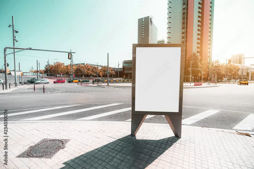 Outdoor empty informational board placeholder with a road junction behind; a blank advertising banner template on the pavement with the crossroad behind; white blank urban billboard mockup